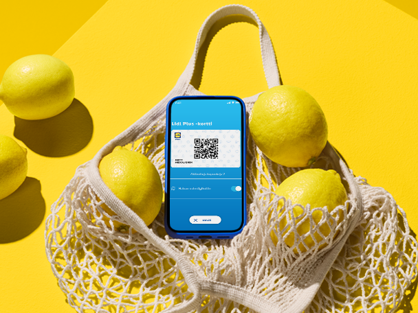 Lidl Plus -sovellus puhelimessa, sitruunoita ja verkkokassi keltaisella taustalla.